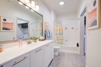 a bathroom with a large mirror and a toilet and a shower